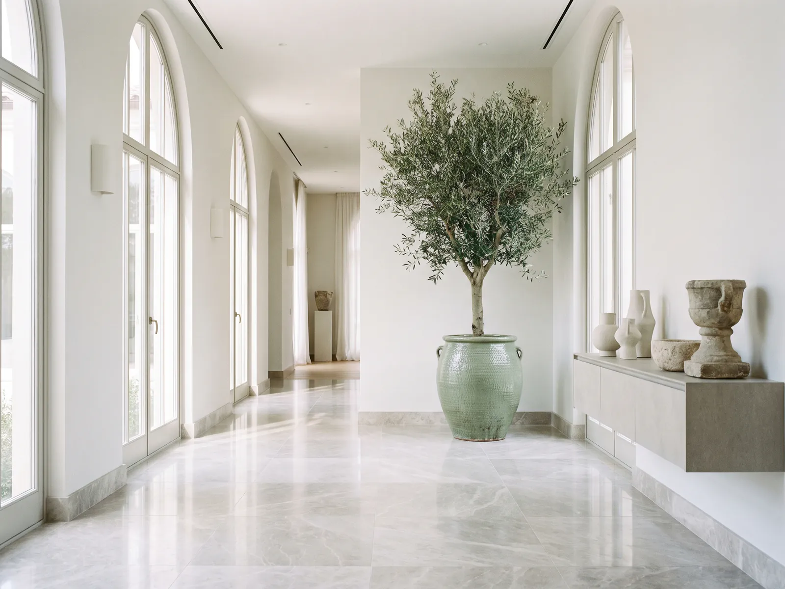 Pale marble floor in an empty villa hallway with tall windows