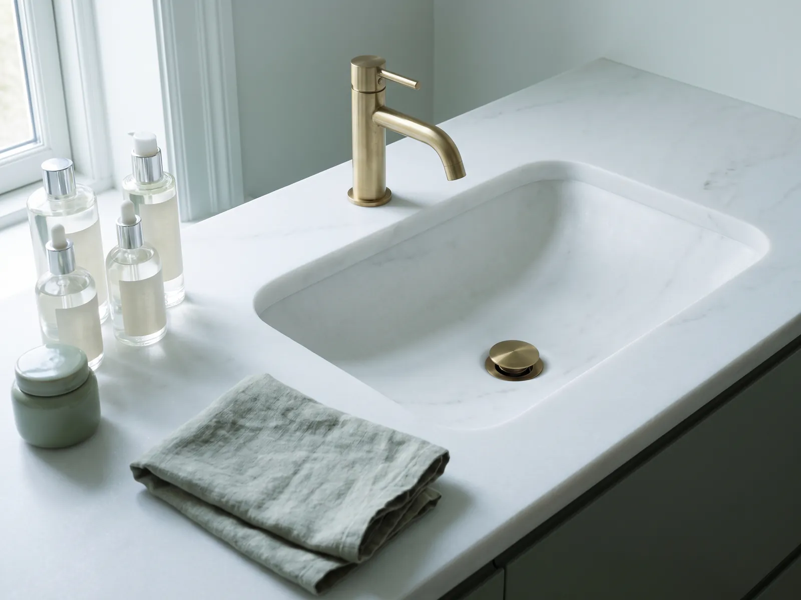 Stone vanity top with integrated basin and brushed brass tap