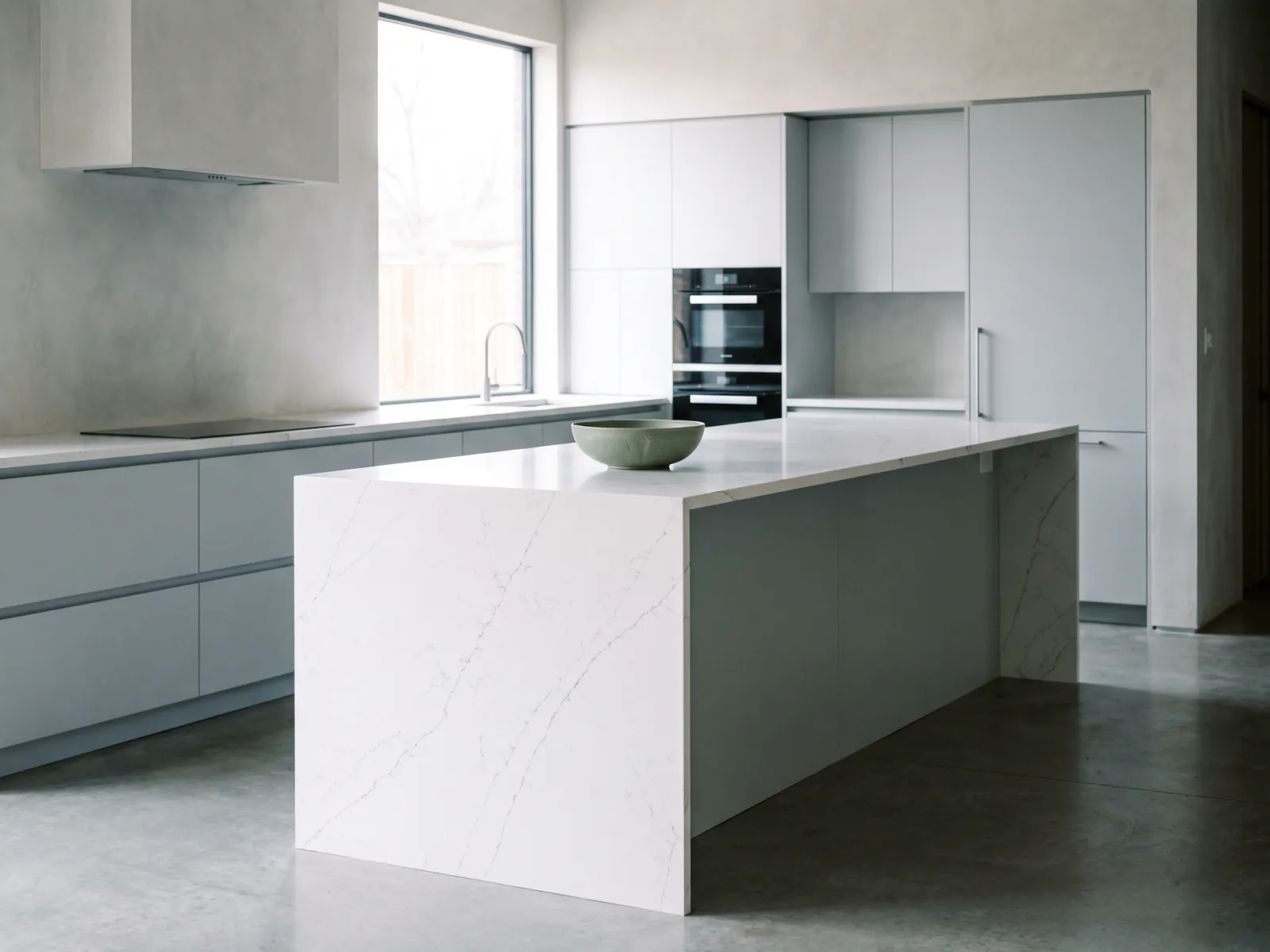 White quartz worktop with waterfall island edge in a modern kitchen