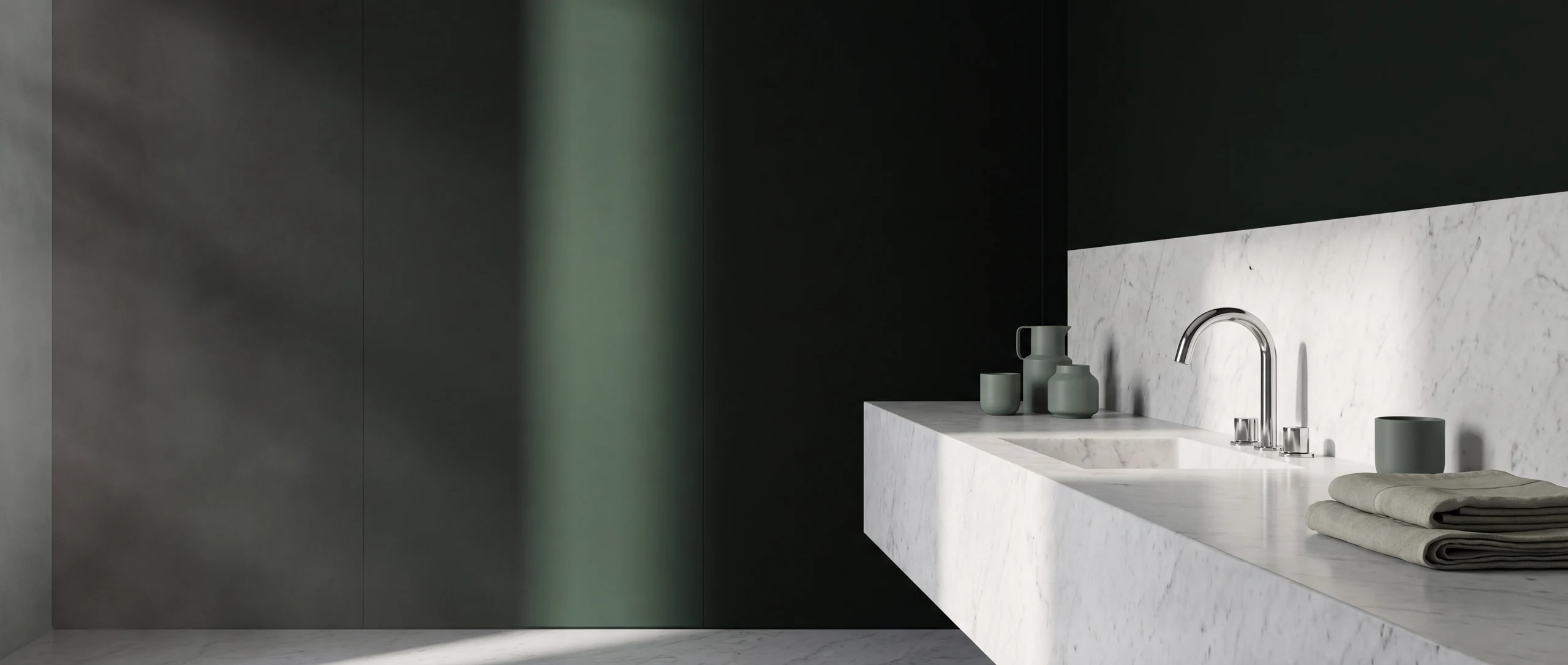 Editorial banner - chrome basin mixer on a long marble vanity against a deep onyx green wall