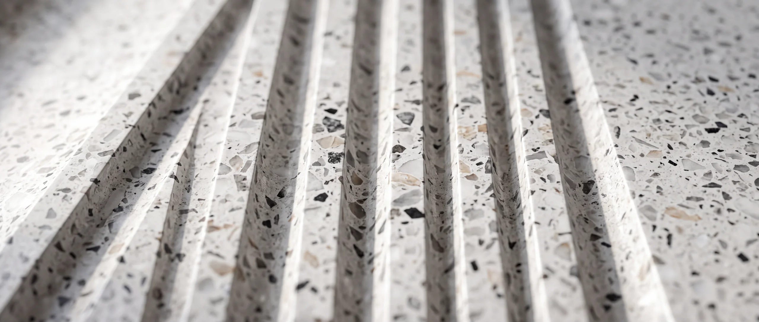 Fluted KalingaStone terrazzo wall panel - raking light across machined grooves