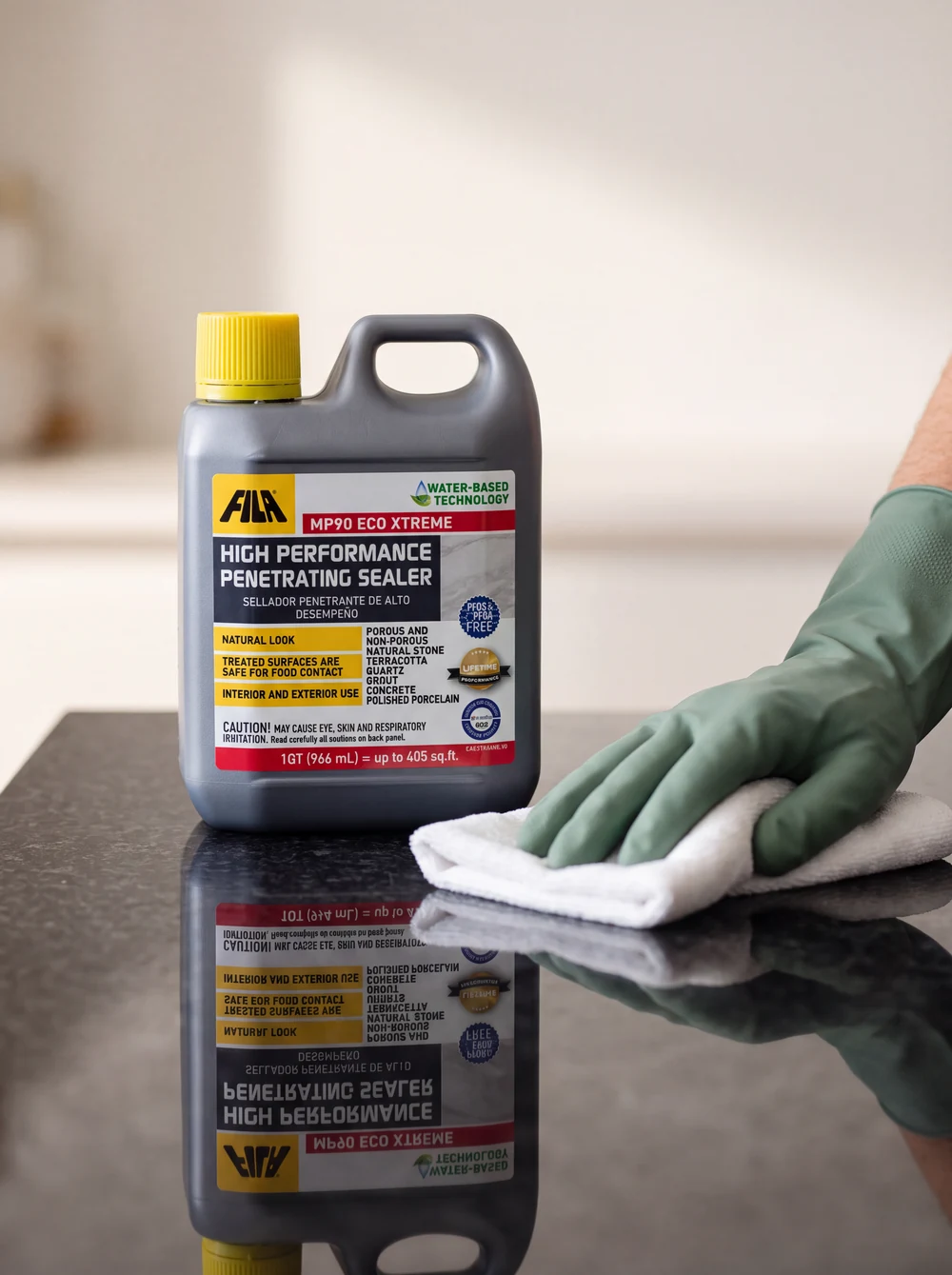A sage-gloved hand polishing a glossy dark stone slab beside the FILA MP90 ECO XTREME sealer jug